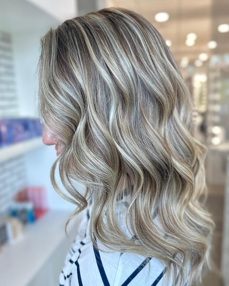 Custom blonding A photo of a bright blonde client showcasing her hair.